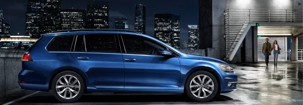 2019 Volkswagen Golf Sportwagen in blue parked on the top of a parking deck in a major city